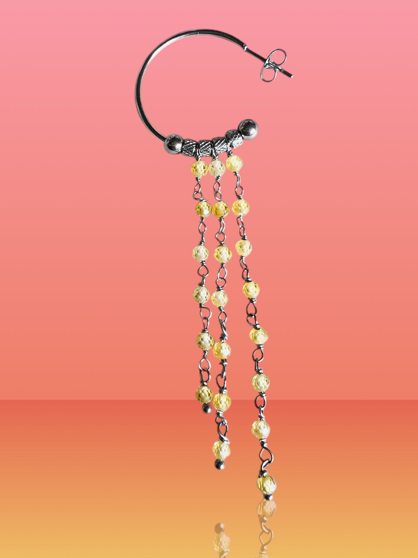 Mono orecchino in acciaio e zirconi gialli