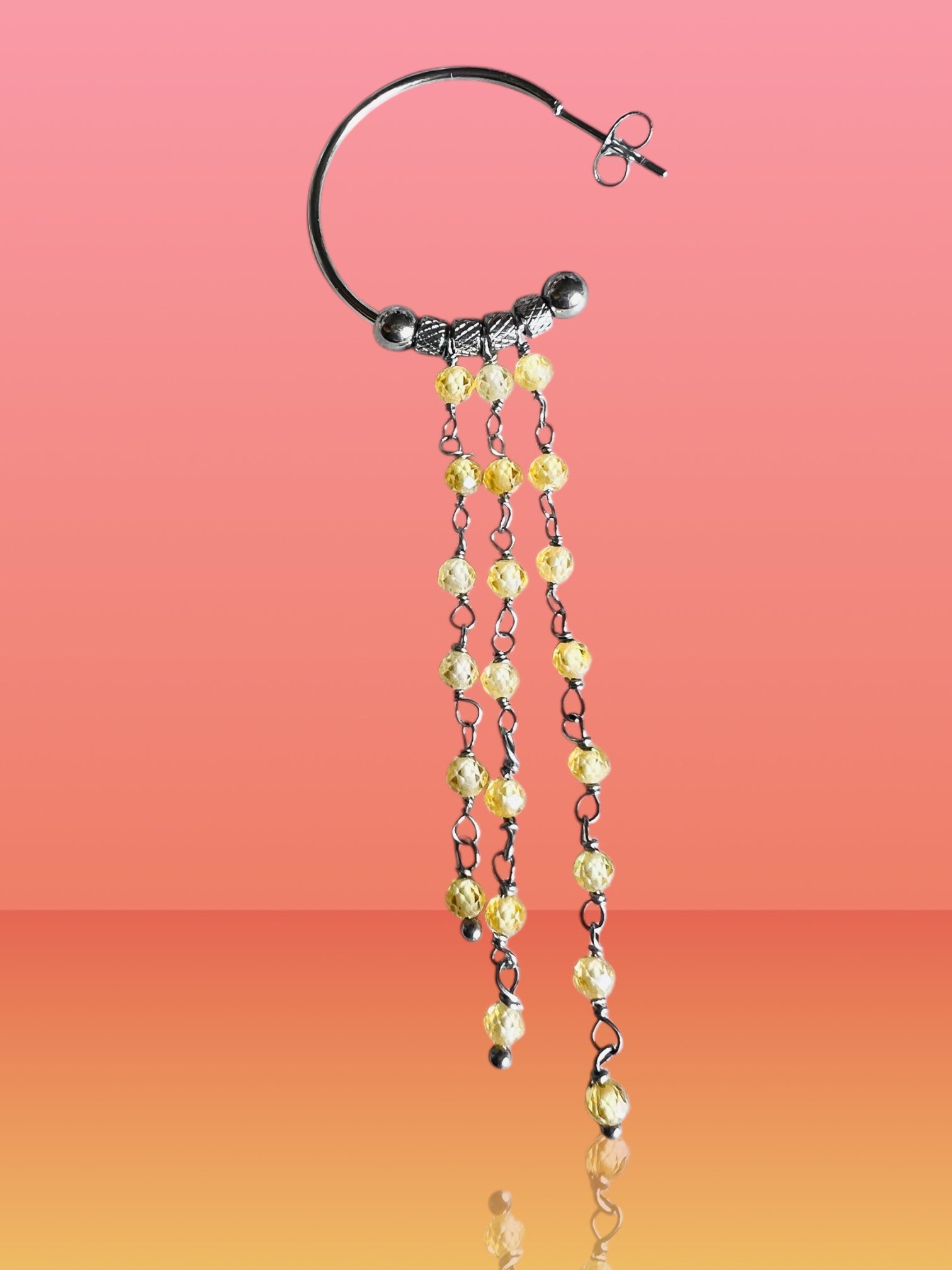 Mono orecchino in acciaio e zirconi gialli